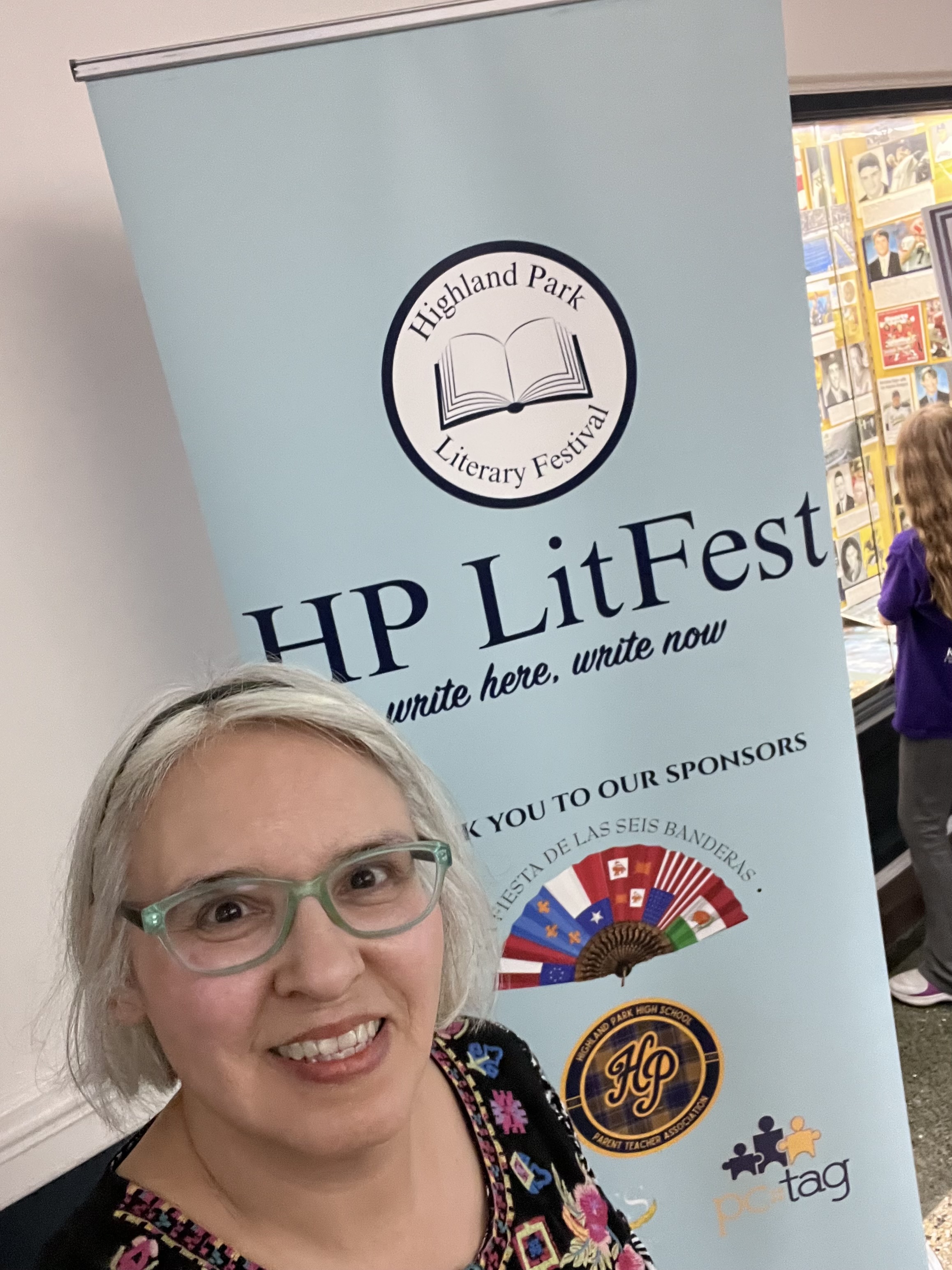 author in front of event poster